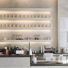 a counter with plates and cups on it in a restaurant or bar area that is empty