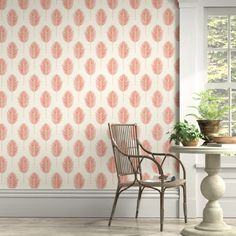 a chair and table in front of a wallpaper with pink leaves on the background