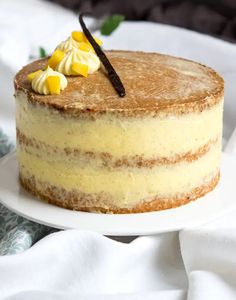 a cake with white frosting and yellow candies on top sits on a plate