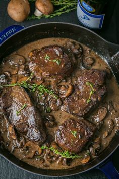 steaks with mushrooms and gravy in a cast iron skillet