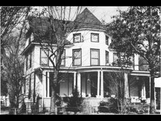 an old black and white photo of a large house with porches on the second floor