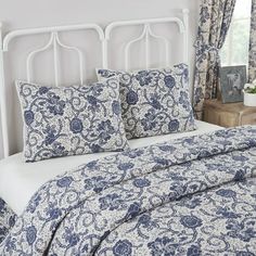 a bed with blue and white comforters in a bedroom