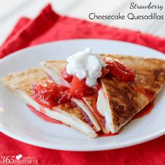 a white plate topped with two quesadillas covered in strawberry sauce and whipped cream