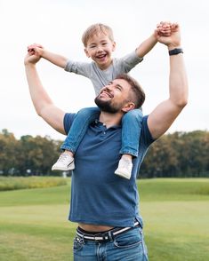 a man holding a little boy on his shoulders