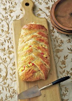 a loaf of bread sitting on top of a wooden cutting board next to a knife