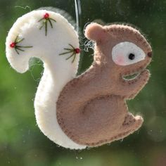 a felt squirrel ornament hanging from a window