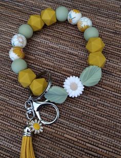 a close up of a bracelet on a table with a flower and a pair of scissors