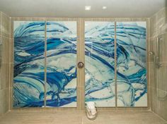 two glass panels in the shower with blue swirls on them