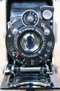 an old fashioned camera sitting on top of a table