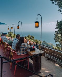 people are sitting at tables overlooking the ocean