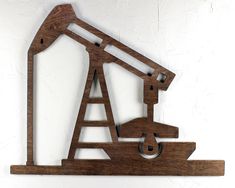 a wooden sign with an oil pump on it's side hanging from the wall