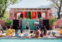 a group of people sitting next to a swimming pool