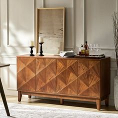 a wooden sideboard sitting on top of a white rug next to a table and chair