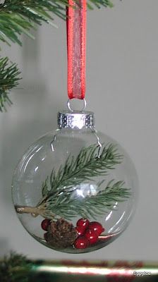 an ornament hanging from a christmas tree with berries and pine cones on it