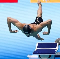 a man diving into the water from a swimming pool