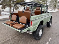 a green pick up truck parked on the side of the road with brown leather seats