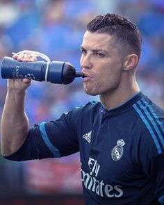 a soccer player drinking from a water bottle