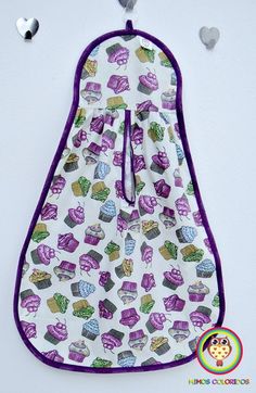 an oven mitt with cupcakes on it and hearts hanging from the side