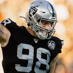 a close up of a football player wearing a helmet and holding his arm in the air