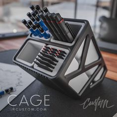 a pen holder filled with pens on top of a table