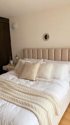 a large bed with white sheets and pillows