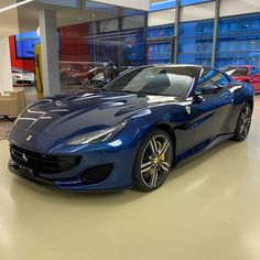 a blue sports car parked in a showroom