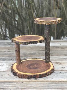 three wood slices stacked on top of each other in the middle of a wooden deck