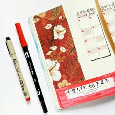 an open notebook with chinese writing on it next to a marker and pen in front of it