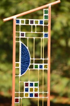 a colorful stained glass window with a wooden stick sticking out of it's side