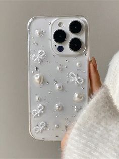 a person holding an iphone case with pearls on it