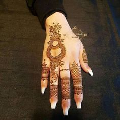 a woman's hand with hennap on it and an intricate design in the middle