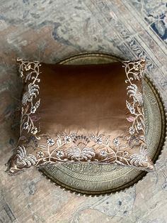 a brown pillow sitting on top of a metal tray