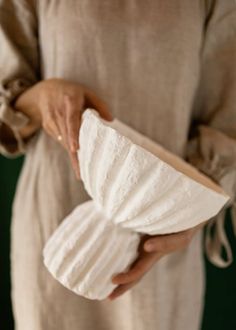 a woman holding a white object in her hands