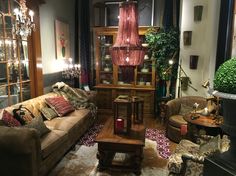 a living room filled with lots of furniture next to a tall potted green plant