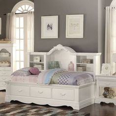 a white bed sitting in a bedroom next to a dresser with drawers on top of it