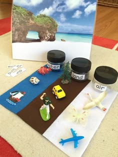 an assortment of toys and magnets sitting on a rug next to a card with the word