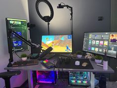 a desk with two computer monitors, keyboard and mouse next to a microphone on a tripod