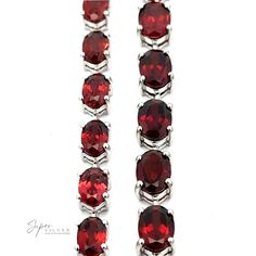 Rows of oval-cut red gemstones set in a Pronged Garnet Bracelet With Rhodium Finish. Garnet Jewelry With Prong Setting For Formal Occasions, Formal Garnet Jewelry With Prong Setting, Oval Ruby Gemstone Tennis Bracelet, Classic Faceted Ruby Jewelry, Classic Garnet Jewelry With Polished Finish, Formal Garnet Jewelry With Gemstone Accents, Formal Garnet Gemstone Jewelry, Elegant Garnet Jewelry With Gemstone Accents, Elegant Silver Garnet Gemstones