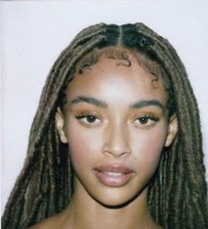 a young woman with dreadlocks looking at the camera