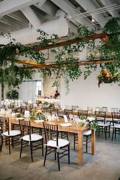 the tables are set up with white linens and greenery for an elegant wedding reception