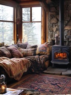 a living room filled with furniture and a fire place in front of a stone wall