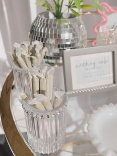 there are many small vases with candy sticks in them on the table next to each other