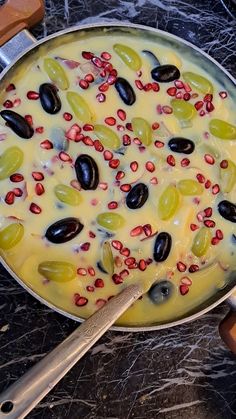 a pan filled with olives on top of a counter next to a spatula