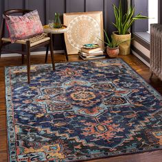 a blue rug with an ornate design on the floor next to a chair and table