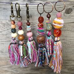 several tassels hanging from hooks on a wooden wall next to scissors and other accessories