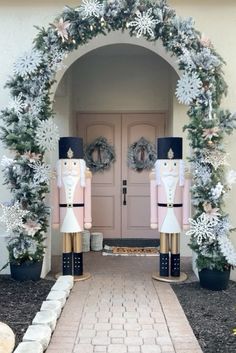 two large nutcrackers are standing in front of a house decorated for christmas