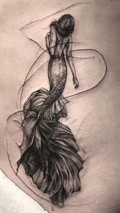 a woman's stomach with a black and white drawing of a mermaid on it