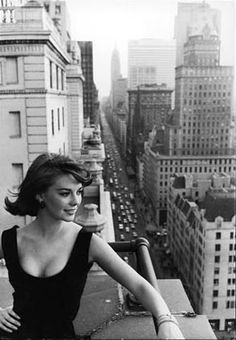 a black and white photo of a woman in the city