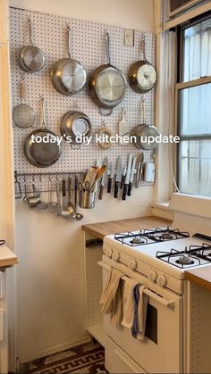 a kitchen with pots and pans hanging on the wall next to stove top oven