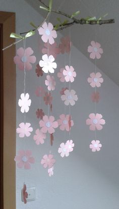 a pink flower mobile hanging from a ceiling